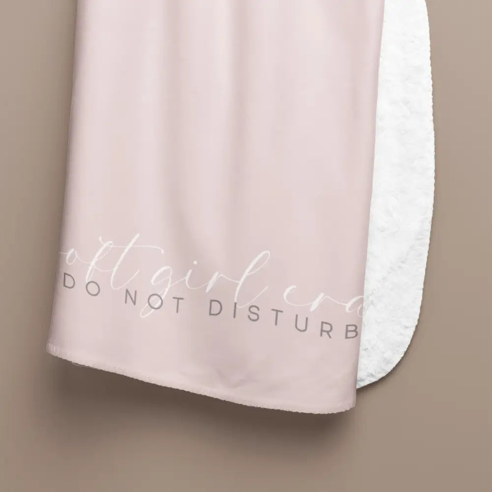 Feminine blush pink fluffy sherpa blanket with empowering text handing to show up close