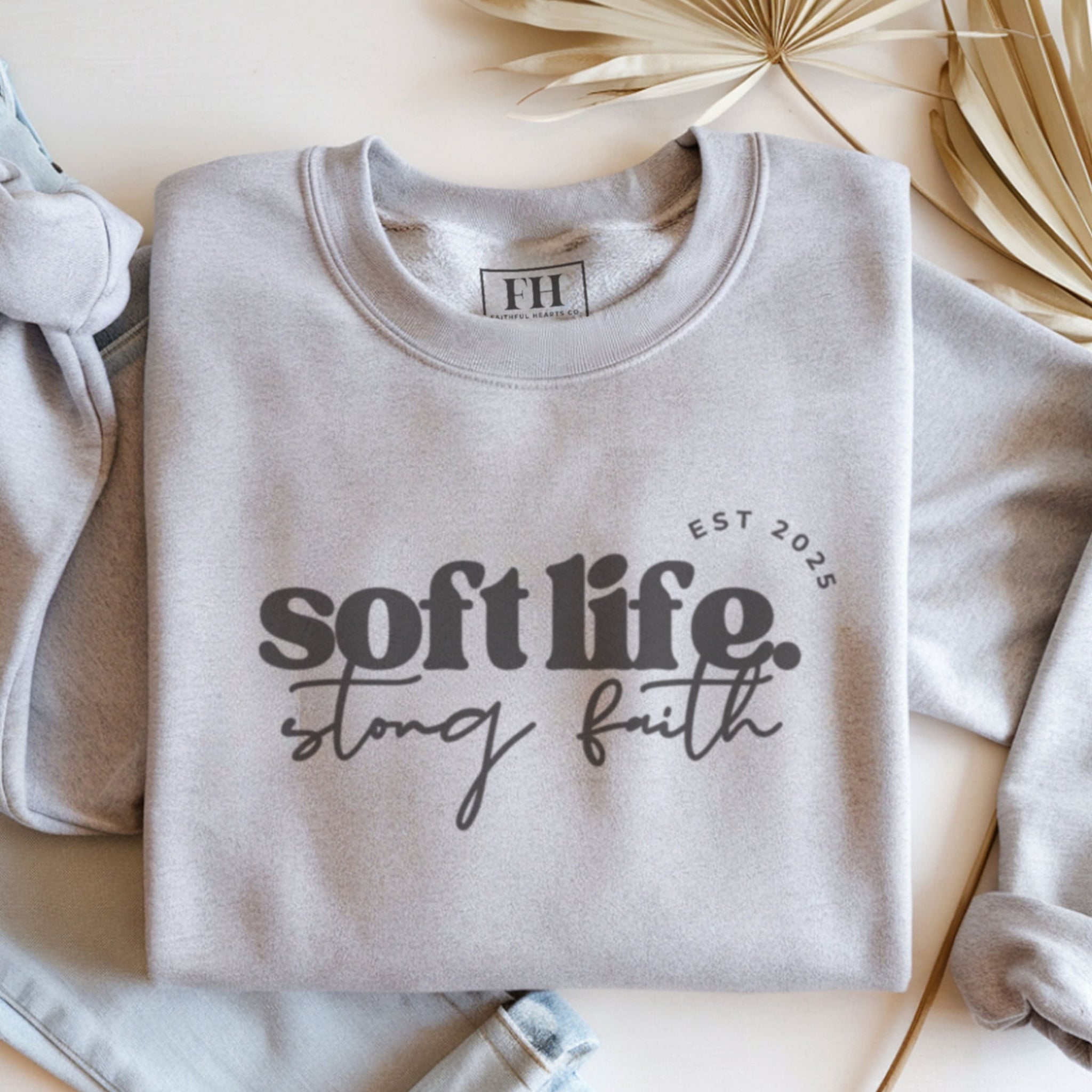 Soft life strong faith crewneck sweatshirt flat lay in grey, minimalist aesthetic Christian apparel by Faithful Hearts Co