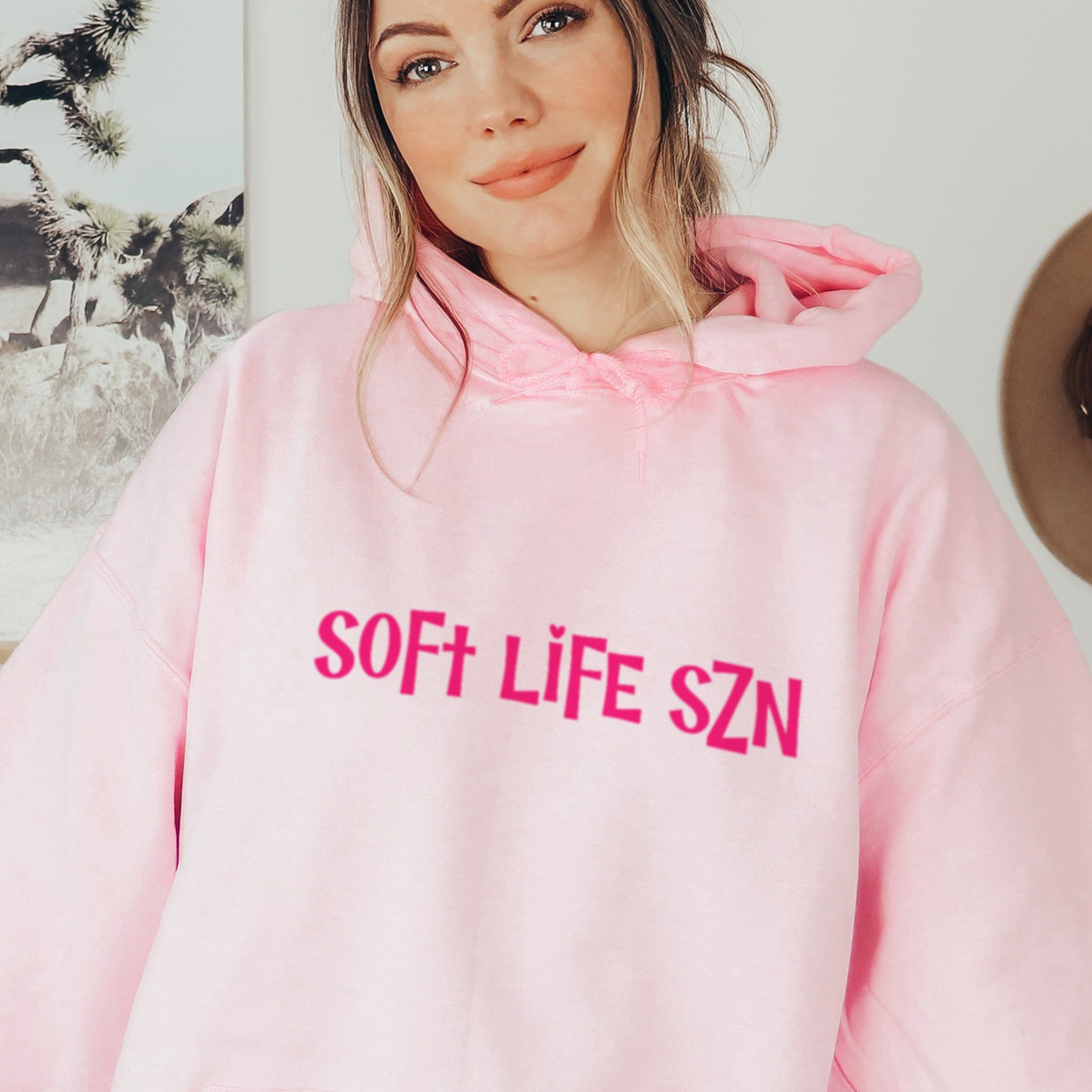 Woman wearing pink soft life SZN hoodie, trendy soft life season sweatshirt with hot pink lettering
