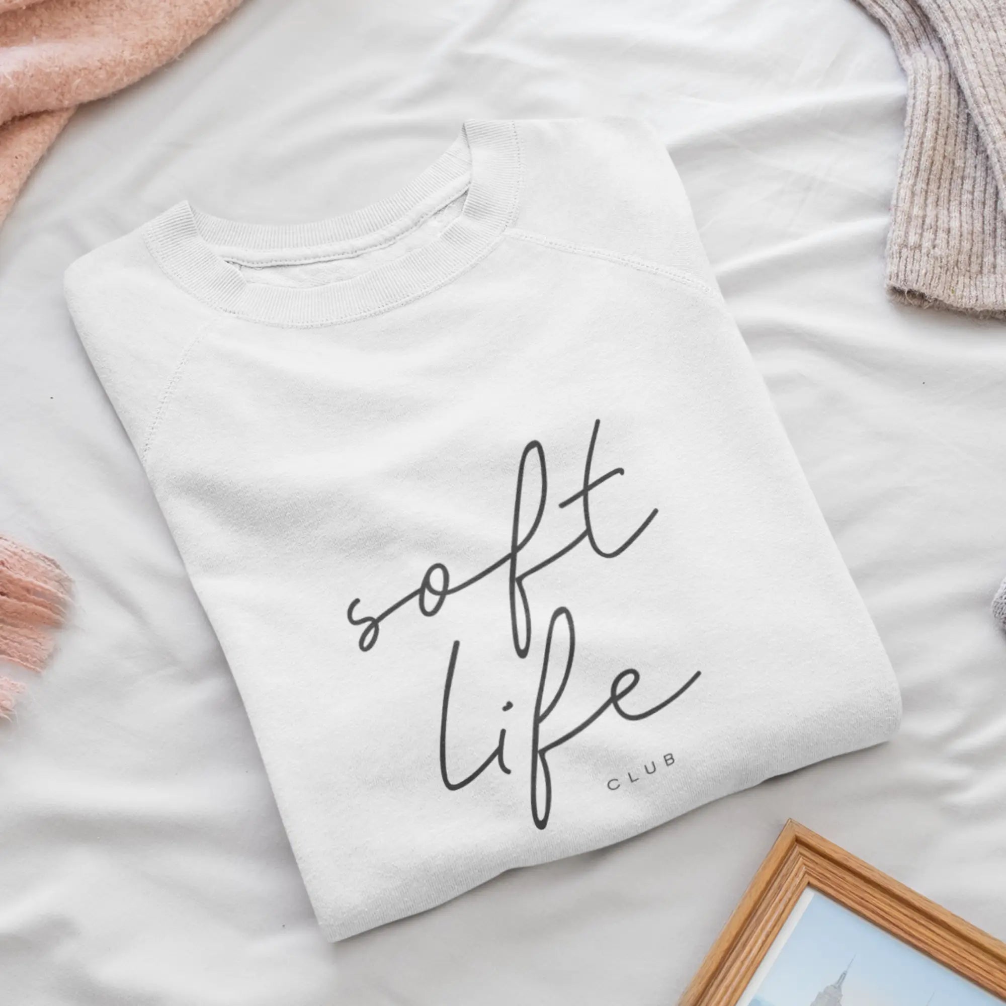 Close-up of 'Soft Life Club' text on breathable white women's sweatshirt, fade-resistant print