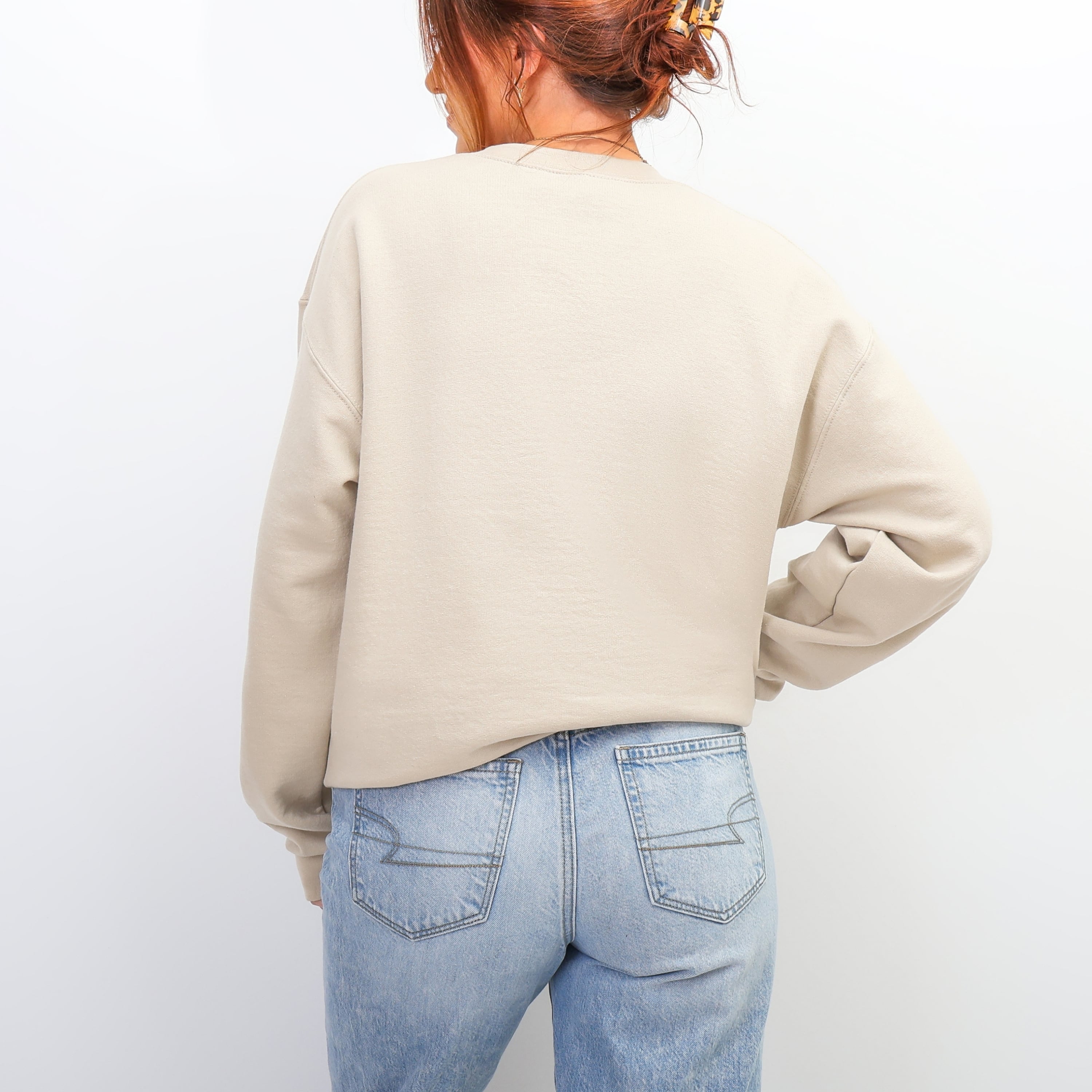 Back view of beige I Decide Who I Become sweatshirt at beach - oversized neutral crewneck for women