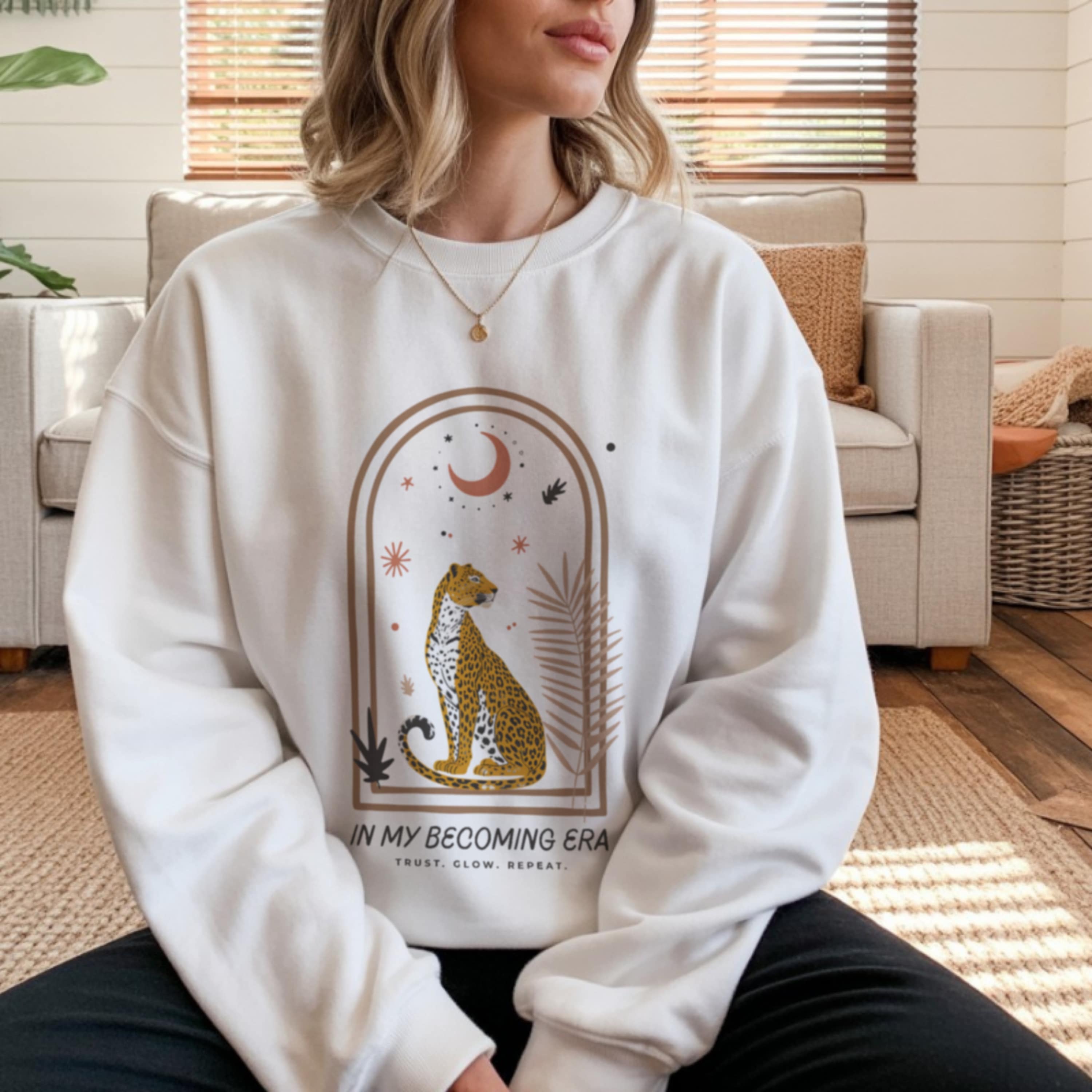becoming era cheetah in archway with moon and botanical elements, Trust Glow Repeat text on women's spirituality sweatshirt