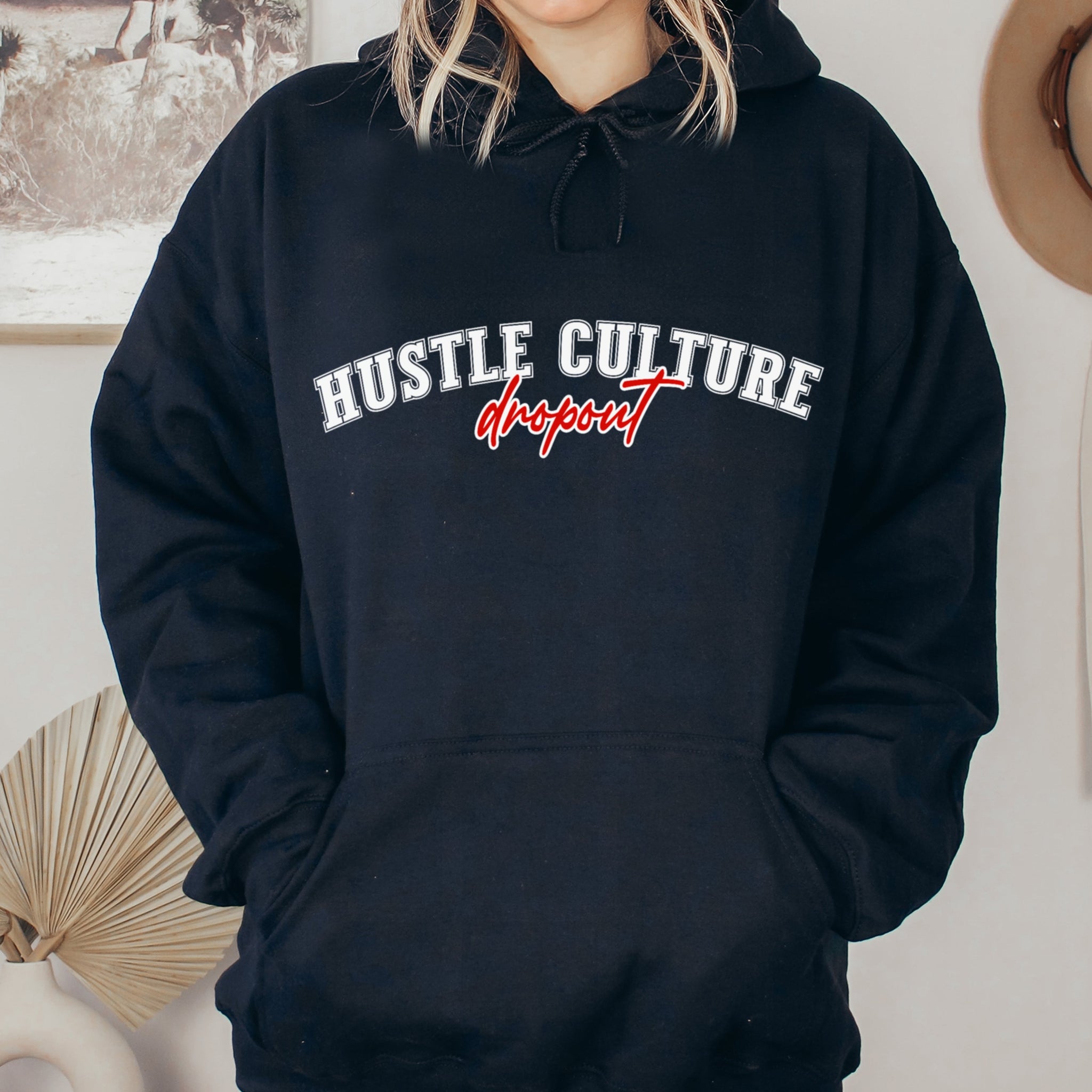 Person wearing a black hoodie with 'Hustle Culture Dropout' text