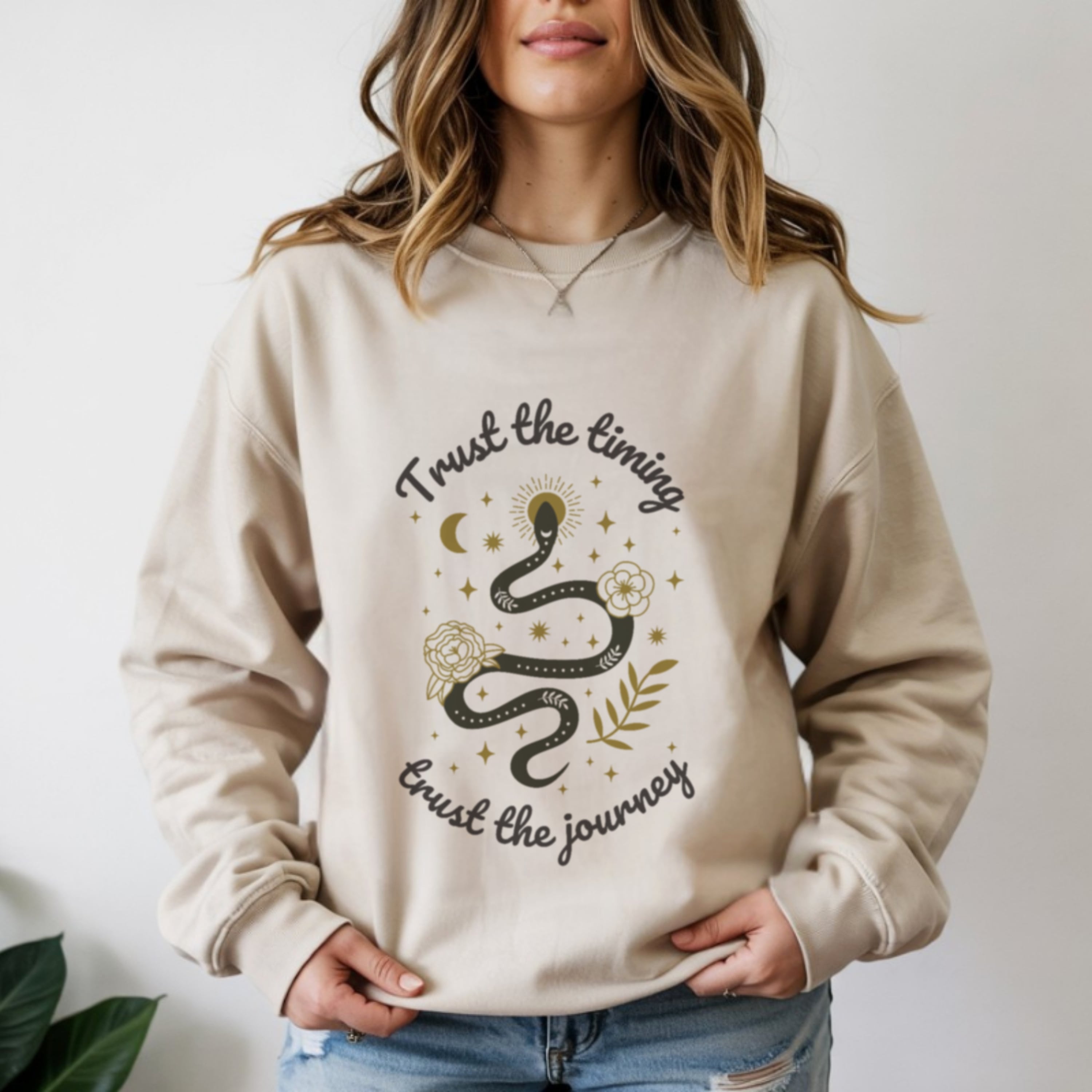 Woman wearing trust the timing trust the journey sand crewneck sweatshirt, boho spiritual faith journey fashion for women