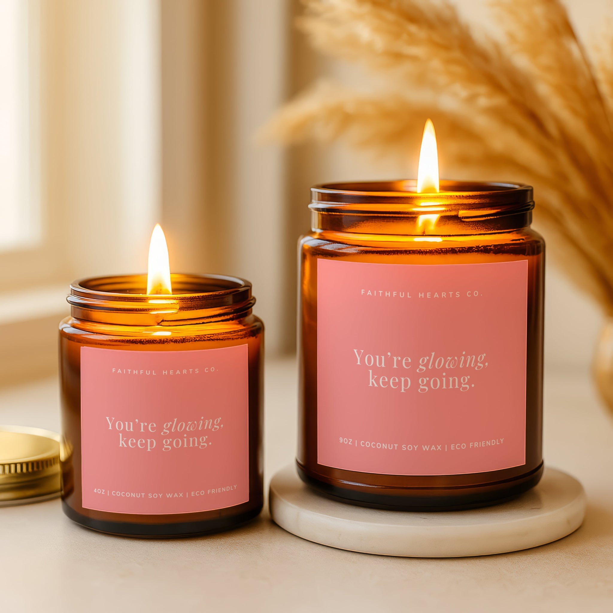 Two lit candles in amber jars with pink labels spiritual gift for women